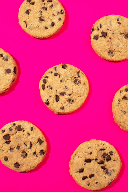 istock Fresh cookies with chocolate chips on a pink background. Dessert, a pastry shop. Pattern. 2150826464