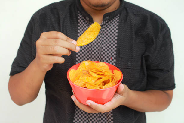 istock A man's hand holds a bowl of potato snack. 2150826700