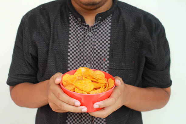 istock A man's hand holds a bowl of potato snack. 2150826703