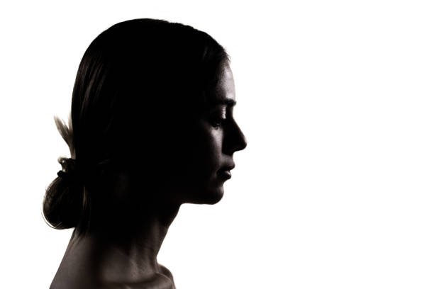 istock Silhouette of a young woman in a dramatic studio portrait 2150828055