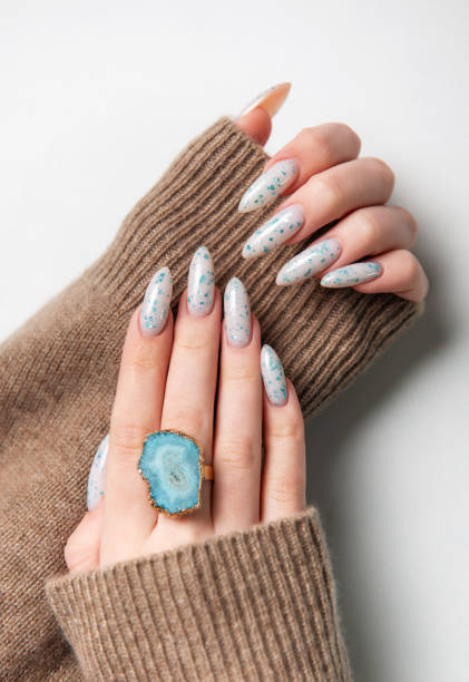 istock Female hands with blue nail design. Blue nail polish manicure. 2150828124