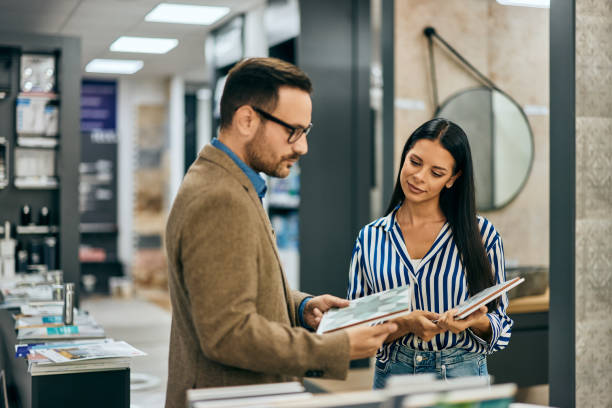 istock A lovely woman searching a perfect design on a ceramic tile, getting a salesman help. 2150828876