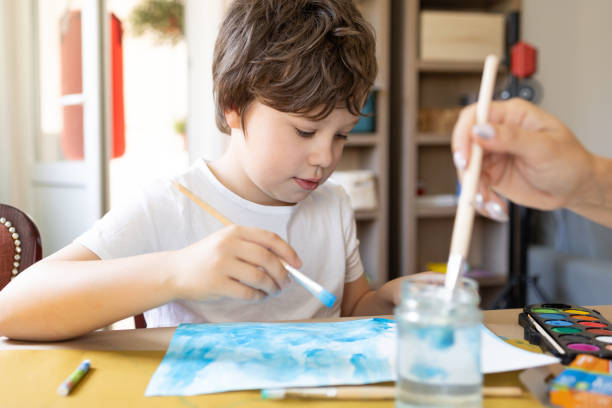 istock A boy paints with watercolors. 2150828930