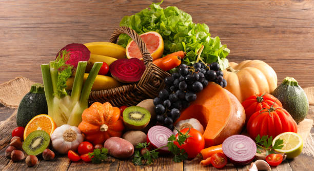 istock assorted fruits and vegetables on wooden background 2150829196