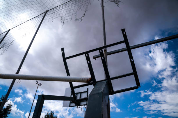 A solitary basketball hoop stands tall against the sky, silently awaiting the next game or player to bring it to life with the sounds of dribbling and the swish of the ball through the net