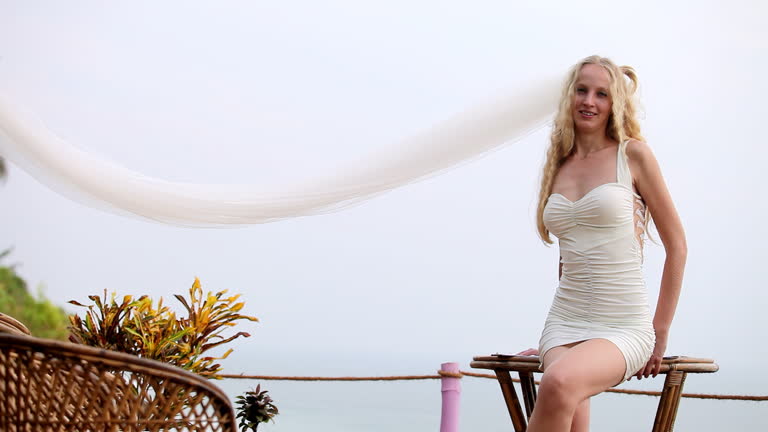 Bride poses for taking marriage photos standing near sea