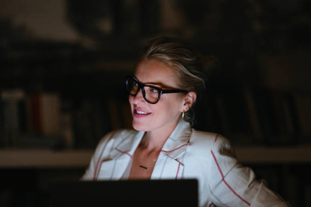 istock Smiling Businesswoman Using A Laptop Computer At Night 2150832139
