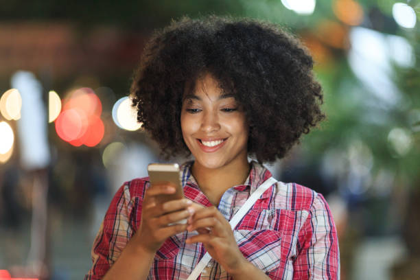 istock Smiling woman using smartphone at night 2150835584