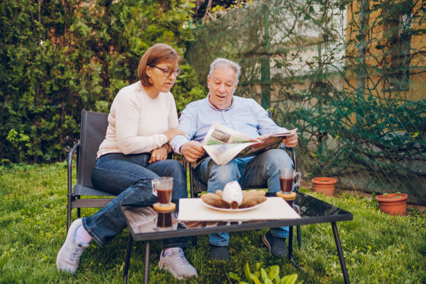 istock A couple enjoying and reading a newspaper while sitting in garden 2150836352