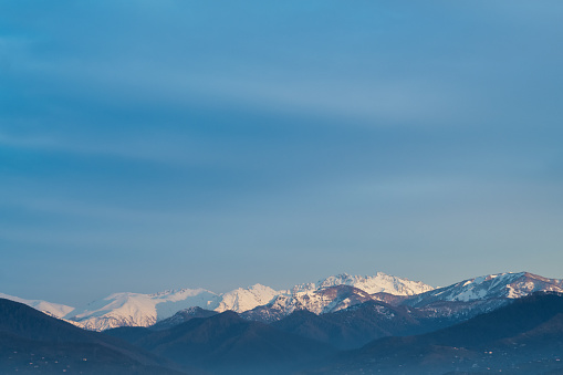 Blue sky and mountains with snow landscape in sunset, Georgia, Caucasus.