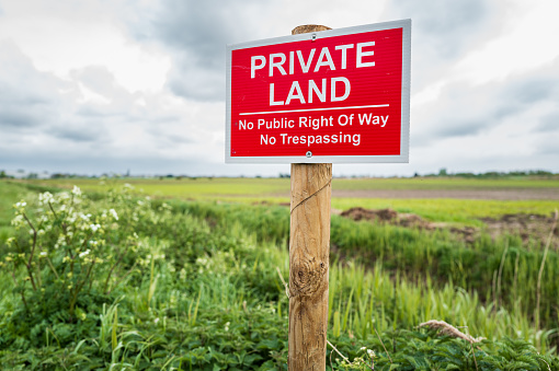 Shallow focus of a newly erected Private Land sign. Installed by the land owner to prevent unauthorised access to the arable land.