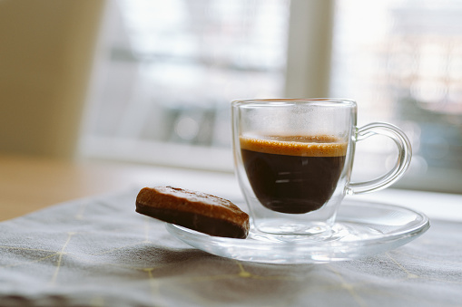 cup espresso coffee with chocolate gingerbread, on table, on blurred background