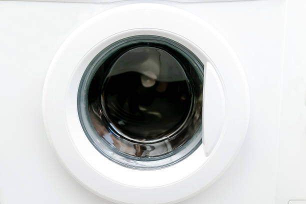 Close-up view of modern white washing machine round front door,interface. Interior view of laundry cabinet.Laundry,cleaning, house work,chores concept