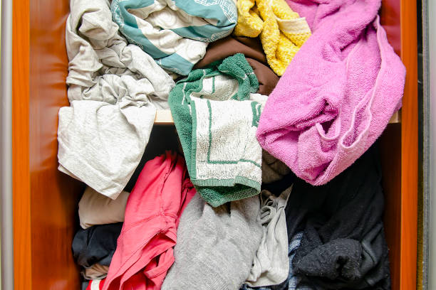 istock Messy closet filled with different used unfresh clothes, sloppily shoved,hanging from shelves. Fast fashion. Pile of dirty cluttered woman's wardrobe stuffed in available space,need for declutter 2150844254
