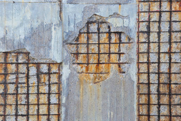 istock Damaged concrete wall without protective concrete cover - Corroded and oxidized reinforcing bars - Concrete fragments dangerously detach from the concrete mass 2150844286