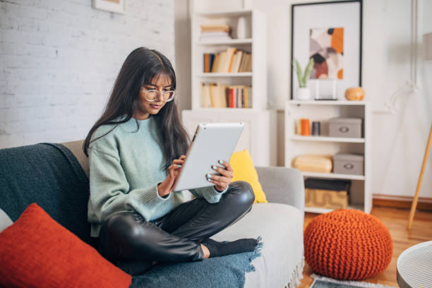 istock Young lady reading tablet comfortably 2150845760