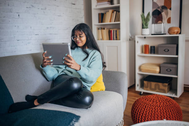 istock Woman engaged with tablet on sofa 2150846321
