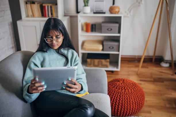 istock Woman reading tablet on a couch 2150846380