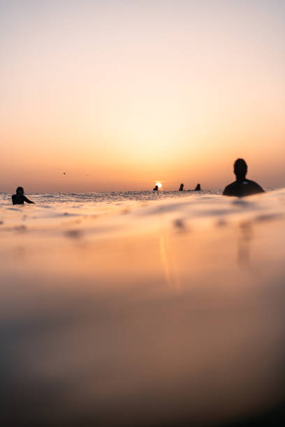 istock Sunset surfers in water 2150846801