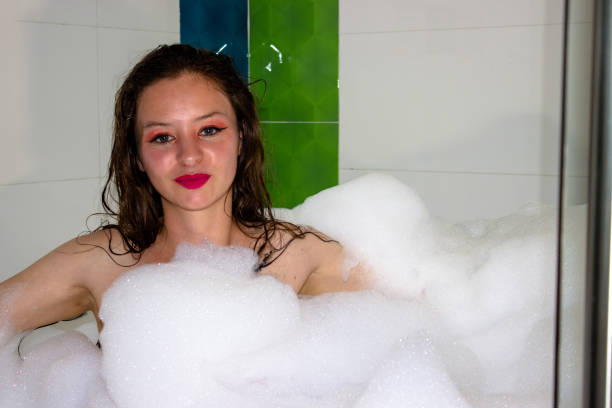 Young woman in a tub in foam