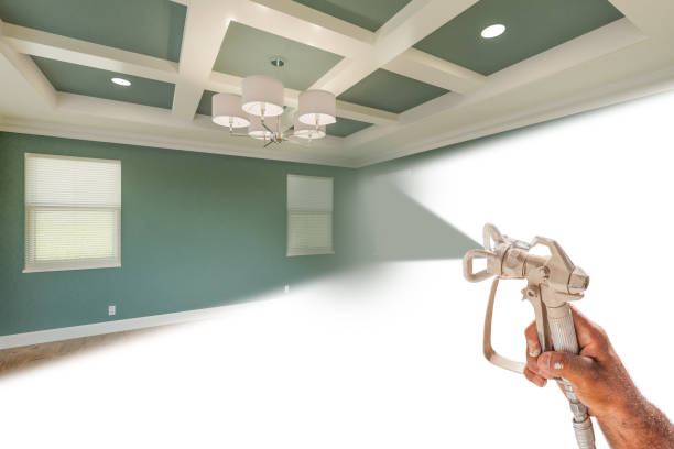 istock Professional Spray Painter Holding Spray Gun Spraying Renovated Room Over White Surface. 2150855987