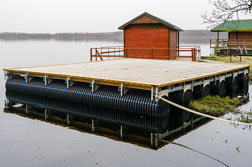 Large floating wooden platforms on pontoons with holiday houses in the lake for leisure and fishing on the water