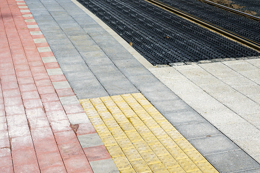 New grey and red pavement, yellow tactile cobblestones for the visually impaired, black plastic grid between tram rails for ground protection