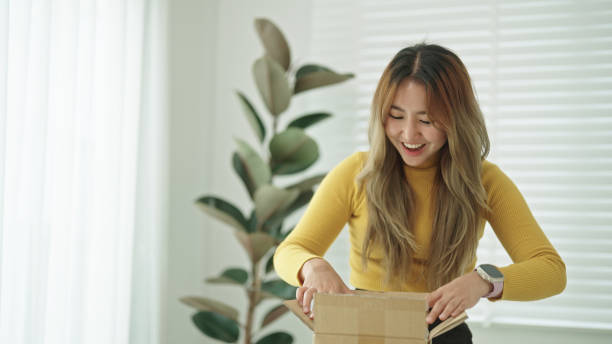 istock Happy woman customer opening delivery package. 2150859845