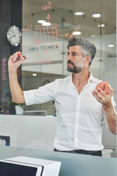 istock Worker with respirator writing scheme on glass 2150860343