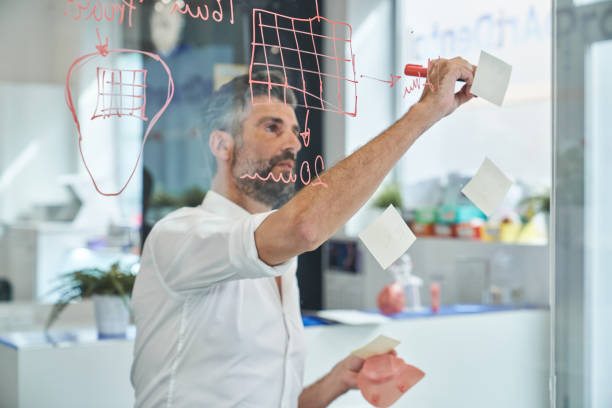 istock Concentrated worker with respirator writing on sticky notes 2150860346