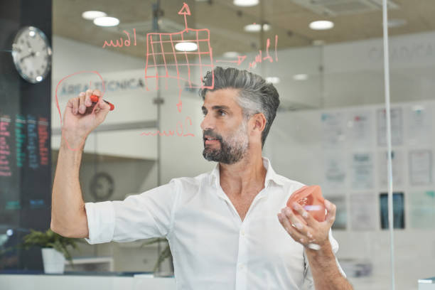 istock Concentrated engineer with model of respirator taking notes 2150860348