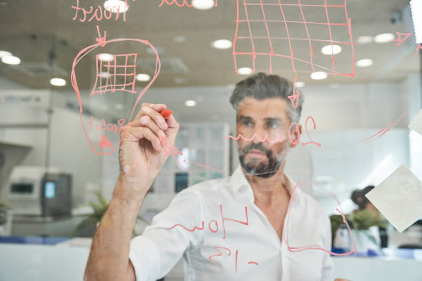 istock Serious bearded man working and writing on glass wall 2150860394