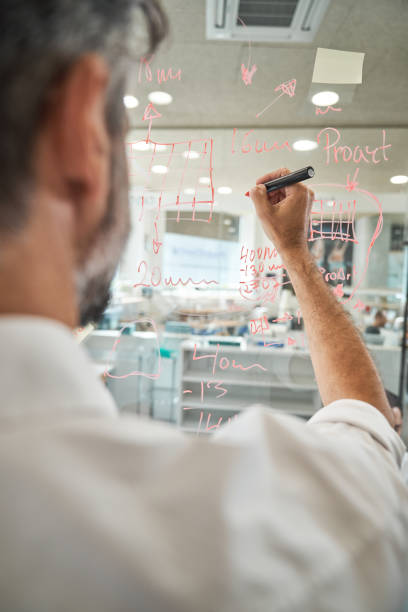 istock Crop man drawing on glass wall in office 2150860398