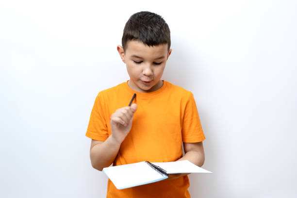 Guy shows expression of decision by raising pen up while holding notebook. Sincere children's emotions.