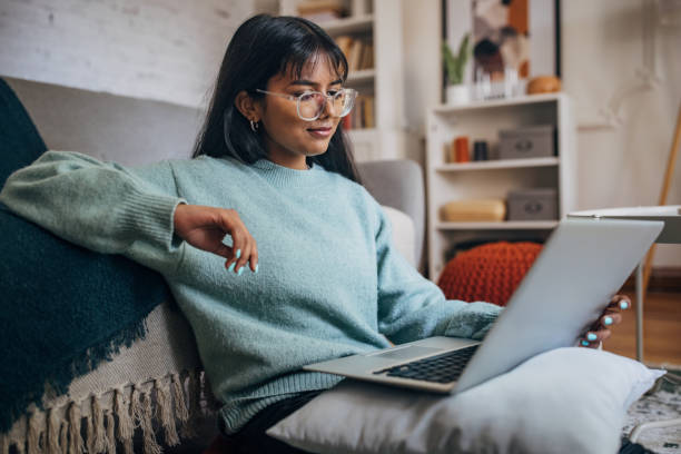 woman relaxing with laptop in modern home - evden çalışma stok fotoğraflar ve resimler