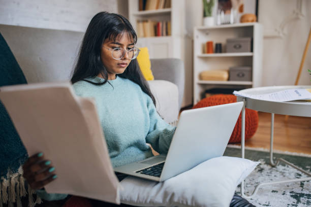 istock Focused woman working with laptop and documents 2150866354