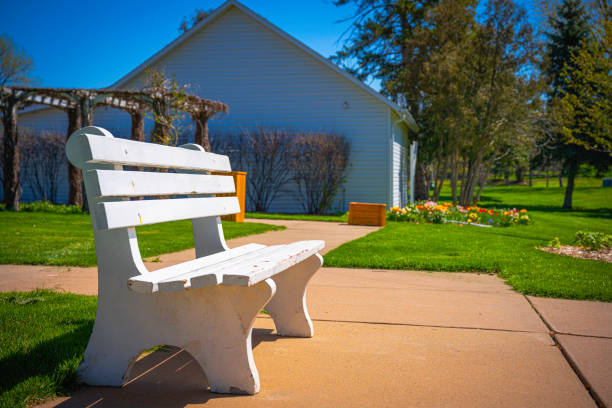 A white wooden resting bench in the park