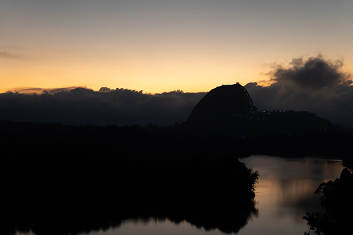 Beautiful sunset in Guatape colombia antioquia near to medellin with the peñol stone clear sky orange light and the lake