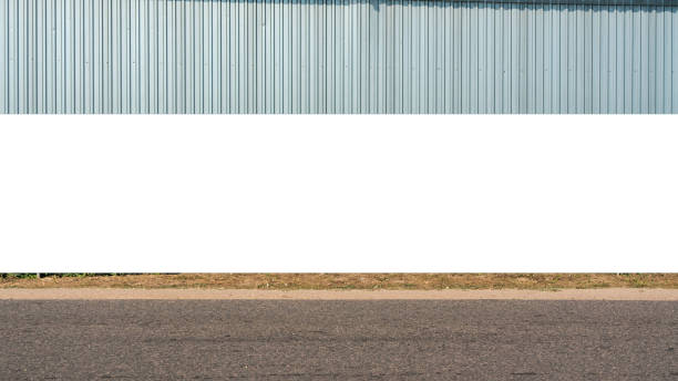 istock Large blank billboard on road with corrugated metal wall in background ready for graphic display or advertising. Perfect for high visibility in urban setting 2150873607