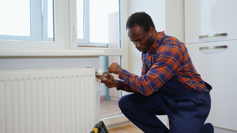 African american worker repairing radiator with wrench