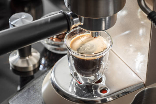 istock Automatic coffee machine. Pouring coffee into the coffee cup closeup. 2150877424