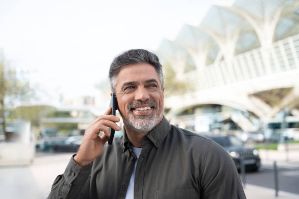 istock 40s mature confident busy businessman entrepreneur using cellphone mobile phone for talking with client, business partners. Successful mid age man investor communicating on smartphone standing outdoor 2150877771