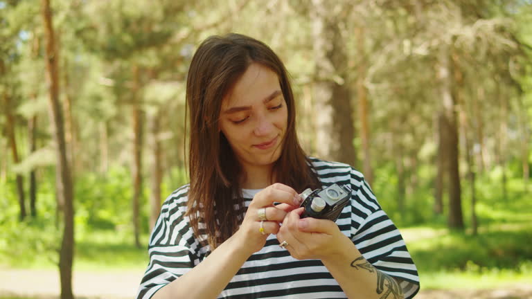 Woman taking photo in forest, tourist using camera , safe travel and explore, walking hiking tours, generation z lifestyle, teenager happy photographer.