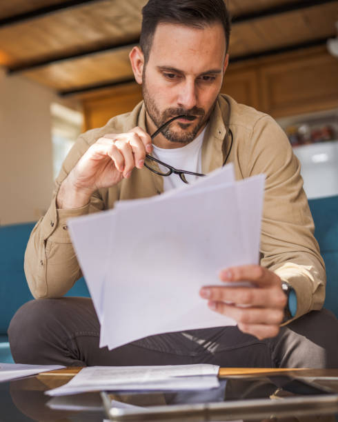istock Adult man read and watch document work at home 2150880477