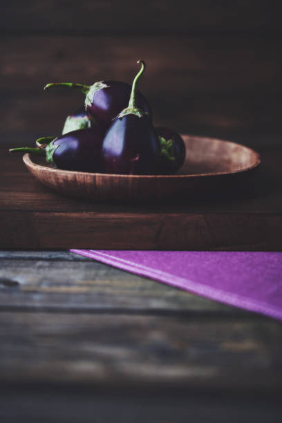Fresh organic eggplant on a rustic wood table with space for copy