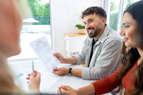 istock Real Estate or Insurance agent with couple looking through mortgage documents. 2150884484