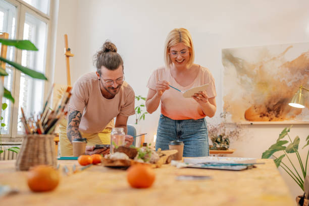 istock Smiling creative painter couple painting on canvas at art studio. 2150890328