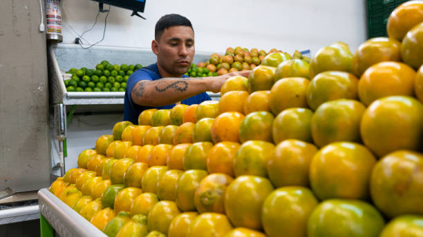 young man arranging oranges.