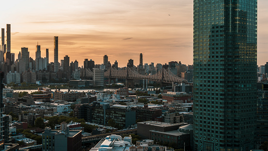 Long Island City, Queens with the view of Queensboro Bridge over the East River with Roosevelt Island and Upper East Side Manhattan at sunset.