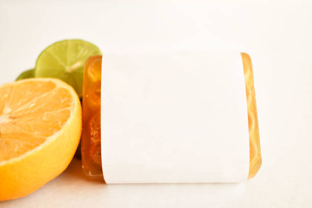 A citrus soap sits delicately against a white backdrop, its vibrant color and fresh scent beckoning for a rejuvenating spa experience.